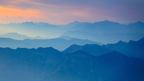 纪录片镜头下的高原山脉晨雾，光线从山脊后方透出，画面开阔，冷色调中带一点暖光